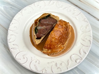 Томлені у вині з овочами яловичі щічки, запечені в тісті зі шпинатом і вершками