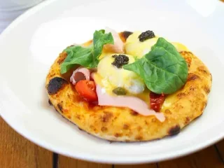 Сніданок піца з шинкою, яйцями пашот, голландським соусом та трюфелем