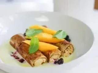 Млинці з сиром, манго, чорною смородиною та англійським соусом