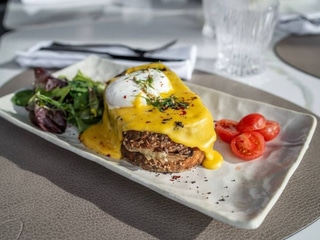 Тост у стилі Крок Мадам із томленою Телятиною, яйцем Пашот та Сирним соусом