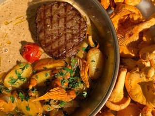 Chateaubriand steak with fried potatoes, porcini mushrooms, and pepper sauce