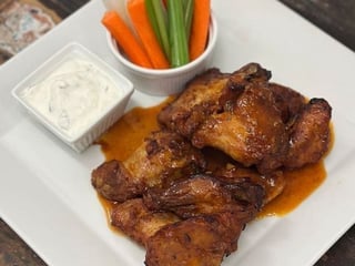 Pečená kuřecí křídla v pikantní marinádě, zeleninové crudité, zakysaná smetana s česnekem a bylinkami, čerstvé pečivo