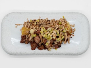 Mollejas de cordero fritas con ajetes sobre patata, ajo negro, pimentón de la Vera setas y tierra de cacahuete