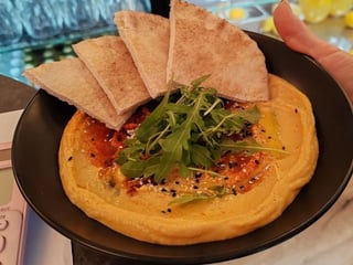 Hummus se sušenými rajčaty a olivovým olejem podávaný s pita chlebem