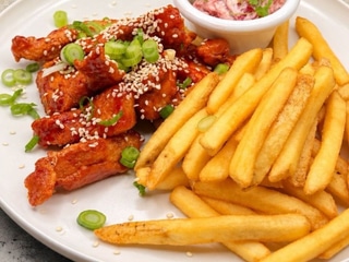 Korean fried chicken – křupavé kuřecí kousky v těstíčku, gochujang glazura, sezam, jarní cibulka, hranolky 170 g (1,3,7,11 )