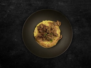 Яловичина томлена у вершковому соусі з печерицями. Подаємо з полентою