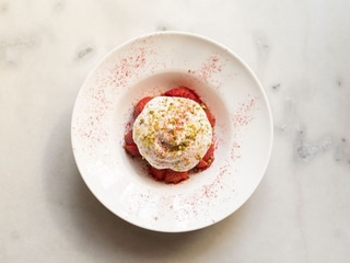 Strawberries with ice cream, whipped cream and pistachios