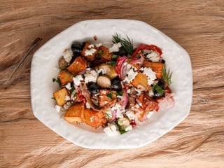 Салат з підсмаженою картоплею, анчоусами, каперсами, вʼяленими томатами та солоною бринзою