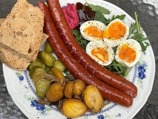 Ситий сніданок з ковбасками, картоплею з грибами та напівкрутими яйцями